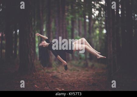 Mädchen schwebend im Wald Stockfoto