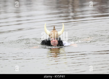 Berlin, Deutschland. 13 Jan, 2018. Ein Teilnehmer nimmt an den Winter schwimmen Karneval am Oranke See, Nordosten Berlin, Deutschland, Jan. 13, 2018. Über 100 Winter schwimmen Enthusiasten und mehr als 1.000 Besucher waren im Winter schwimmen Karneval hier am Samstag angezogen. Credit: Shan Yuqi/Xinhua/Alamy leben Nachrichten Stockfoto