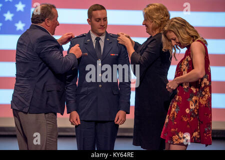 Us Air Force 2nd Lieutenant Christopher Wright's Familie Pins seinen Rang auf seine Uniform und Baskenmütze während seiner Inbetriebnahme Zeremonie, Dez. 20, 2017. Clemson University Armee und Air Force Reserve Officer Training Corps Einheiten eine gemeinsame Inbetriebnahme Zeremonie in der Tillman Hall Auditorium. Us-Armee Brig. Gen. Stephen B. Owens, Direktor des Joint Staff, South Carolina National Guard, war der Hauptredner. ( Stockfoto