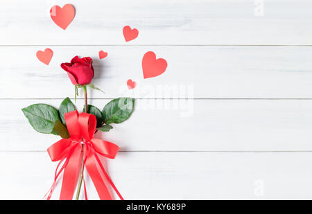 Rote Rose mit rotem Band und Papier Herz auf weißem Holz bcakground, zum Valentinstag Konzept Stockfoto