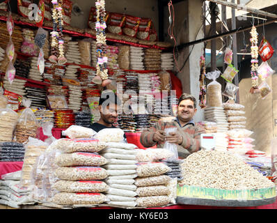 Jammu, Indien. 12 Jan, 2018. Indische Menschen kaufen üblichen eatables wie Erdnüsse, Popcorn und andere Snacks für den Lohri Festival von einem Straßenrand shop inJammu. Auf der lohri Tag Leute fliegen Drachen in den Tag und in der Nacht ein Lagerfeuer, um das Ereignis zu feiern. Lohri, eines der wichtigsten Festivals des Punjab, markiert den Höhepunkt des Winters und wird im Monat Januar jedes Jahr gefeiert. Credit: Shilpa Thakur/Pacific Press/Alamy leben Nachrichten Stockfoto