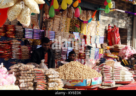 Jammu, Indien. 12 Jan, 2018. Indische Menschen kaufen üblichen eatables wie Erdnüsse, Popcorn und andere Snacks für den Lohri Festival von einem Straßenrand shop inJammu. Auf der lohri Tag Leute fliegen Drachen in den Tag und in der Nacht ein Lagerfeuer, um das Ereignis zu feiern. Lohri, eines der wichtigsten Festivals des Punjab, markiert den Höhepunkt des Winters und wird im Monat Januar jedes Jahr gefeiert. Credit: Shilpa Thakur/Pacific Press/Alamy leben Nachrichten Stockfoto