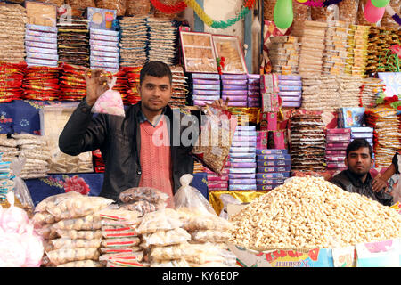 Jammu, Indien. 12 Jan, 2018. Indische Menschen kaufen üblichen eatables wie Erdnüsse, Popcorn und andere Snacks für den Lohri Festival von einem Straßenrand shop inJammu. Auf der lohri Tag Leute fliegen Drachen in den Tag und in der Nacht ein Lagerfeuer, um das Ereignis zu feiern. Lohri, eines der wichtigsten Festivals des Punjab, markiert den Höhepunkt des Winters und wird im Monat Januar jedes Jahr gefeiert. Credit: Shilpa Thakur/Pacific Press/Alamy leben Nachrichten Stockfoto