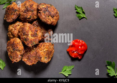 Schiefer Tafel mit hausgemachten frikadellen aus Schweinefleisch, Rindfleisch und Gemüse mit Tomatensauce gemacht Stockfoto