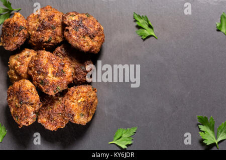 Schiefer Tafel mit hausgemachten frikadellen aus Schweinefleisch, Rindfleisch und Gemüse mit Kräutern hergestellt Stockfoto