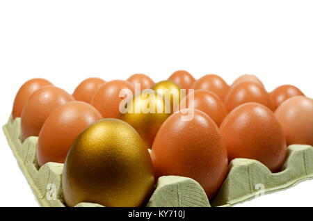 Goldene Ei in einer Box zu normalen Eier mit weißen isoliert Stockfoto