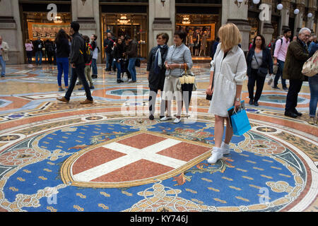 Die Galerie Vittorio Emanuele Innenraum, Mailand, Italien. Wappen des Hauses Savoyen dargestellt auf den Mosaikboden in der Galleria Vittorio Emanuele II. Stockfoto