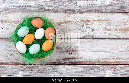 Bunte echten Eier auf künstlichen grünen Gras im Korb für Ostern Hintergrund Stockfoto