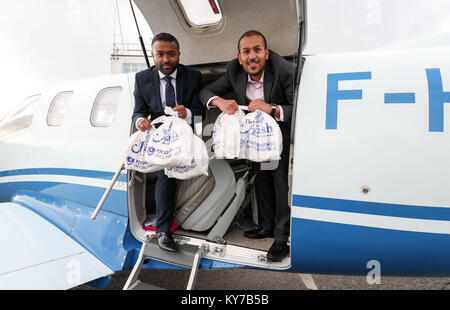 Brüder Faz (rechts) und Jaf Ahmed von der Akash Restaurant in Fareham, Hampshire, laden ein Curry Gerichte zum Mitnehmen auf eine Ebene im Solent Flughafen, Lee-On-The-Solent, so kann es nach Frankreich für Britische ex-pats James Emery und Freunde an Saucats Flugplatz geflogen werden, südlich von Bordeaux. Stockfoto