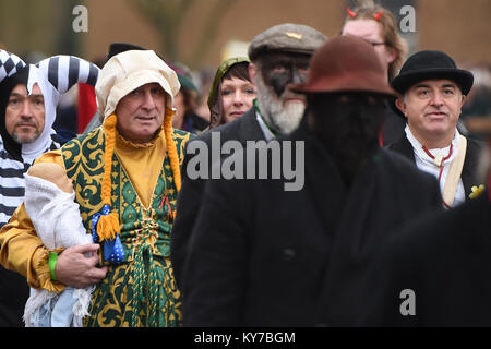 Menschen in Tracht Parade durch die Stadt während der 39Th Whittlesey Stroh tragen Festival in Cambridgeshire. Stockfoto