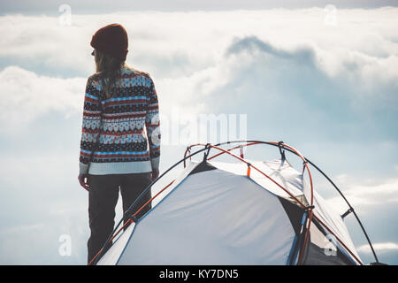 Frau Reisenden auf Berggipfel und Zelt Camping Nebel wolken landschaft auf dem Hintergrund Reisen Lifestyle Konzept Abenteuer Ferien im Freien Stockfoto