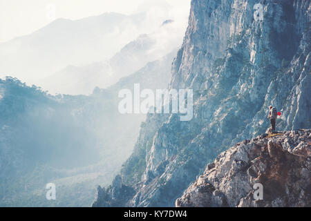 Frau Reisenden auf Klippe wandern mit Rucksack Reisen Lifestyle Konzept Abenteuer aktiv Urlaub Outdoor Rocky Mountains Landschaft Luftaufnahme auf der Rückseite Stockfoto