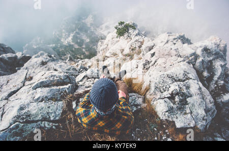 Reisende Mann allein auf felsigen Gipfel über den Wolken Reisen Lifestyle erfolg konzept Abenteuer aktiv Urlaub Outdoor Top View Stockfoto