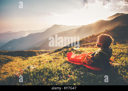 Man Relaxen im Schlafsack genießen Berge Sonnenuntergang Landschaft Reisen Lifestyle camping Konzept Abenteuer Sommer Urlaub Outdoor wandern mountainee Stockfoto