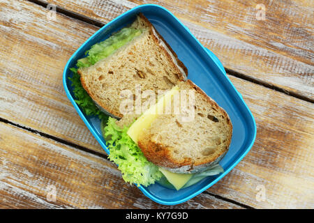 Rustikales Brot Sandwiches mit Käse und Salat in Lunch Box auf Holzmöbeln im Landhausstil Oberfläche Stockfoto