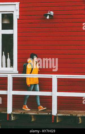 Reisende Frau Wandern in Norwegen Dorf rote Haus Wand an Hintergrund Reisen Lifestyle Konzept winter Urlaub im Freien Stockfoto