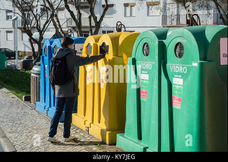 Frau, Müll in einem strassenrand Papierkorb in Portugal. Stockfoto