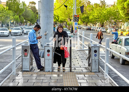 Isfahan, Iran - 23. April 2017: Ein erwachsener muslimische Frau geht auf den Busbahnhof durch eine automatische ticket Drehkreuz. Stockfoto