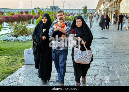 Isfahan, Iran - 23. April 2017: Die iranische Familie, zwei Frauen in einem schwarzen islamischen Tschador gekleidet, und ein Mann mit einem Baby auf dem Arm, Spaziergang rund um Naghsh Stockfoto