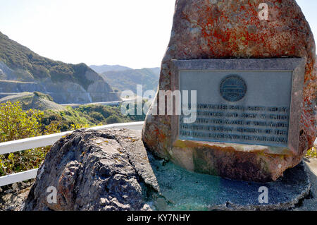 Remutaka passieren Aussichtspunkt und Erinnerungsstein mit Straßenarbeiten im neuen Abschnitt dahinter. Neuseeland Nordinsel. Remutaka-Bereich. Plaque Stockfoto