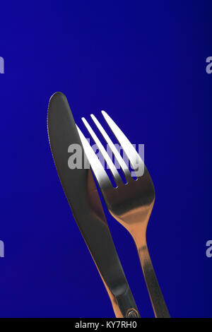 Extreme Nahaufnahme von Gabel und Messer auf blauem Hintergrund Stockfoto