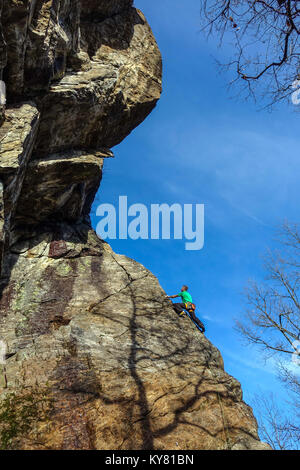 Männliche Kletterer auf steilen Granit Felsen mit rotem Rock und blauer Himmel Stockfoto