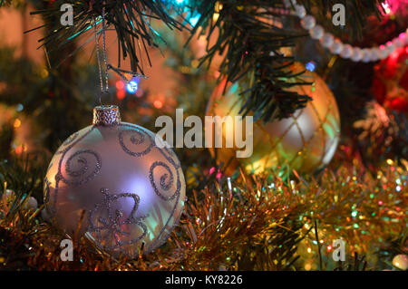 Zwei Weihnachten Dekorationen auf einem Baum in gedämpftes Licht Stockfoto