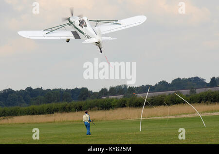 Piper PA-25 Pawnee Segelflugzeug tug herauf ein Banner schleppen an wenig Gransden Kinder in Not Airshow. Kabel anschließen Stockfoto