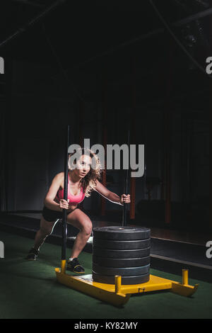 Schlitten schieben Frau schob Gewichte Training Übung Stockfoto