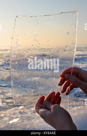 Eis Hintergrund. Frau Hände ice Holding. Im Winter am Plattensee, Ungarn. Stockfoto
