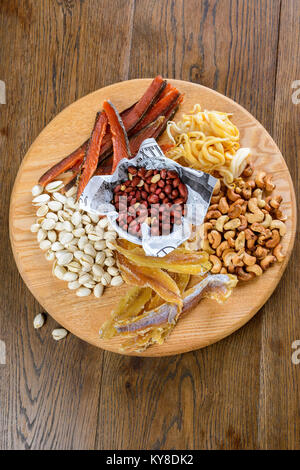 Verschiedene Nüsse und gesalzene Snacks geschmackvoll mit Bier Stockfoto