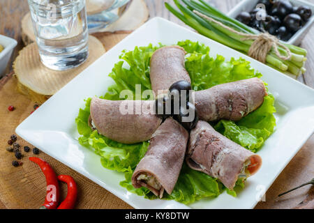 Fleisch, Brötchen mit Oliven auf weiße Platte garniert mit Wodka Stockfoto