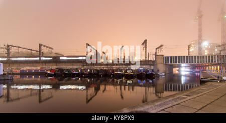 Ein Zug nähert sich der London St Pancras railway station auf einem Viadukt über das Regent's Canal auf eine stimmungsvolle neblige Nacht, mit langen Exposition motion Stockfoto