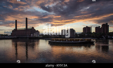 London, England, Großbritannien - 12 August, 2014: Die Schornsteine der Lots Road Power Station und der Welten Ende Rat Immobilien sind gegen den Sonnenuntergang ov Silhouette Stockfoto