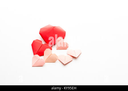 Horizontale Sammlung verschiedener Größen von origami Papier Herzen zum Valentinstag isoliert auf weißem Hintergrund Stockfoto