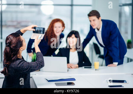 Geschäftsfrau ihre Kollegen schießen auf Handy Kamera Stockfoto