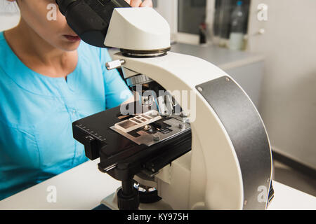 Weibliche Forscher mit einem Mikroskop. Labor in der Tierklinik. Nahaufnahme eines Mikroskops. Stockfoto