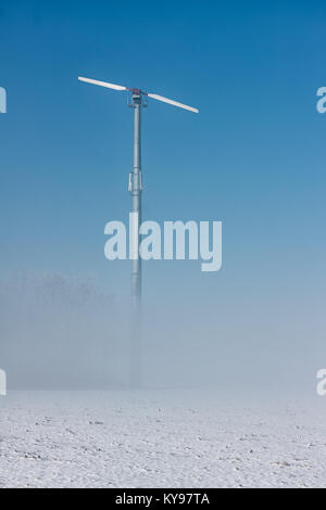 Holländische Winterlandschaft mit Bodennebel und wind turbine Stockfoto