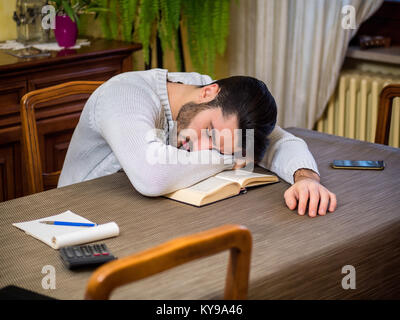 Müde junge Mann Einschlafen lesen Buch Stockfoto