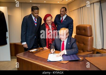 Us-Präsident Donald Trump Zeichen das Martin Luther King Jr. National Historical Park Act während einer Zeremonie an Bord der Air Force One 8. Januar 2018 in Atlanta, Georgia. Suche auf Isaac Newton Farris jr., Links, Neffe von Dr. König, Alveda König, Center, Nichte des getöteten Civil Rights Leader und Bruce Levell der nationalen Vielfalt Koalition für Trumpf, rechts. Stockfoto