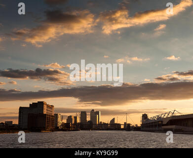 London, England, UK - 31. Juli 2010: Sonnenuntergang wirft einen roten Himmel über den Londoner Docklands Finanzviertel und die Gewässer des Royal Victoria Dock. Stockfoto