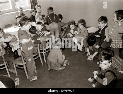 Dieses Foto zeigt 1964 einen Kindergarten in Studenci, der das Gebäude, den Spielplatz und die Kinder während der täglichen Aktivitäten zeigt. Stockfoto