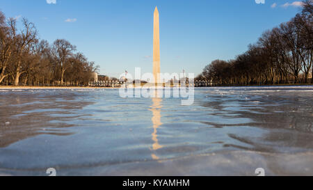 Das Washington Monument in der Mitte eines gefrorenen, eisige Lincoln Memorial Reflecting Pool in Washington, D.C. an einem hellen, kalten Tag gesehen Stockfoto