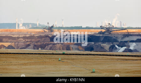 Panoramablick über einen großen braunkohletagebau Mine mit Schaufelradbaggern und anderen großen Maschinen, zwei Braunkohlekraftwerke im Hintergrund. Stockfoto