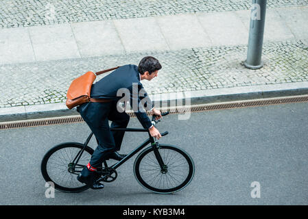 Junger Mann mit Anzug beim Reiten ein Fahrrad Stockfoto