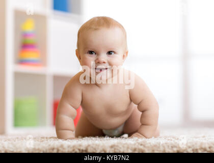 Smiling baby boy getragen in der Windel krabbeln zu Hause auf dem Boden Stockfoto