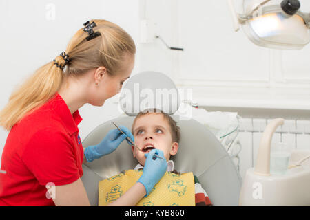 Weiblichen Zahnarzt untersucht die Zähne der Patienten Kind. Kind Mund weit geöffnet im Zahnarztstuhl. Close-up. Medizinisches Konzept Stockfoto