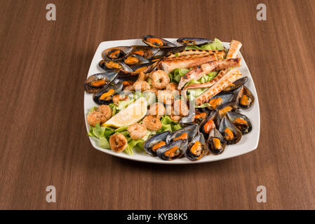 Teller mit Muscheln Tintenfisch und Garnelen auf einem Tisch Stockfoto