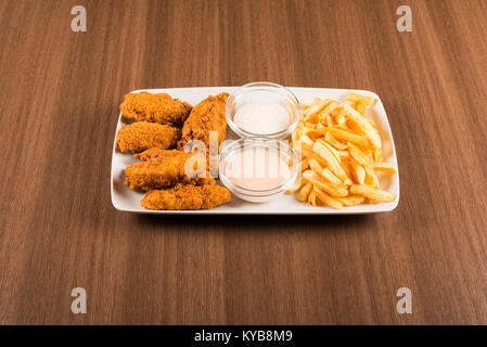 Chicken Wings mit Bratkartoffeln auf einem weißen Teller Stockfoto