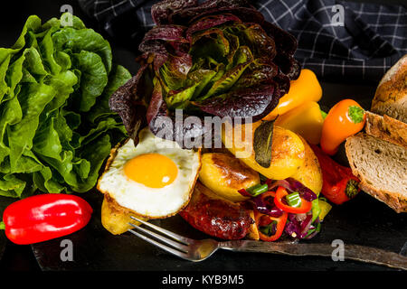 Gebackene Kartoffeln und Wurst mit gebratenem Gemüse Stockfoto